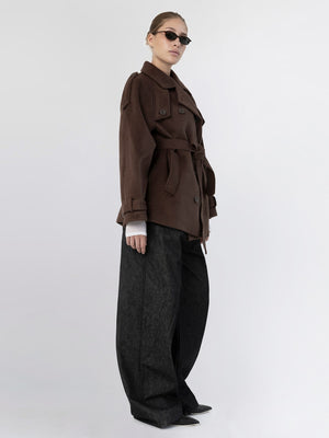 A model showcases a stylish brown trench coat with a belt, paired with oversized black pants and sunglasses, representing MEOTINE's chic aesthetic.
