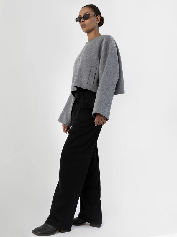 A model showcases a stylish gray cropped sweater paired with black wide-leg pants, exuding a modern look by MEOTINE.
