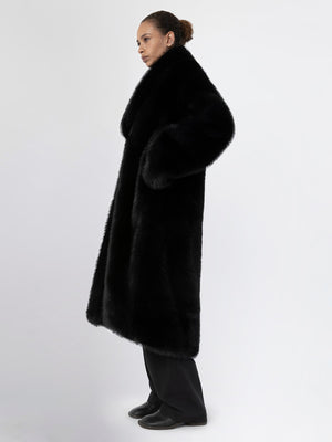 A model wearing a luxurious black faux fur coat by MEOTINE, showcasing a stylish and elegant silhouette against a plain background.