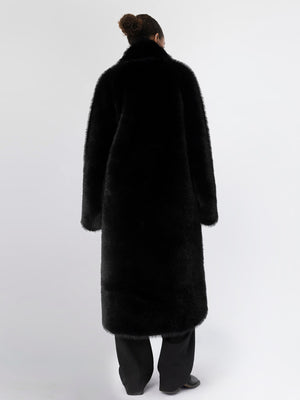A model wearing a long, black faux fur coat from MEOTINE, showcasing a sleek and elegant back view against a plain background.