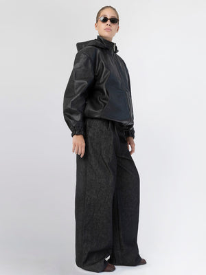 A model showcases a stylish black leather jacket paired with wide-leg dark jeans, exuding a modern vibe for MEOTINE.