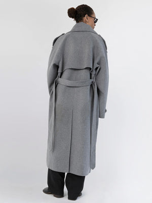 A model showcases a stylish gray MEOTINE coat from the back, featuring a belted waist and a flowing design.