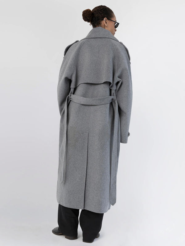 A model showcases a stylish gray MEOTINE coat from the back, featuring a belted waist and a flowing design.