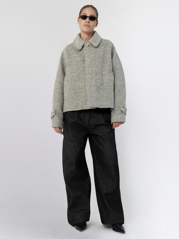 A model wears a cozy grey MEOTINE jacket paired with wide black trousers, showcasing a stylish and relaxed look.