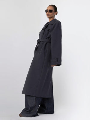 A model showcases a stylish dark trench coat paired with wide-leg jeans, exuding a chic vibe, featuring MEOTINE's signature design.