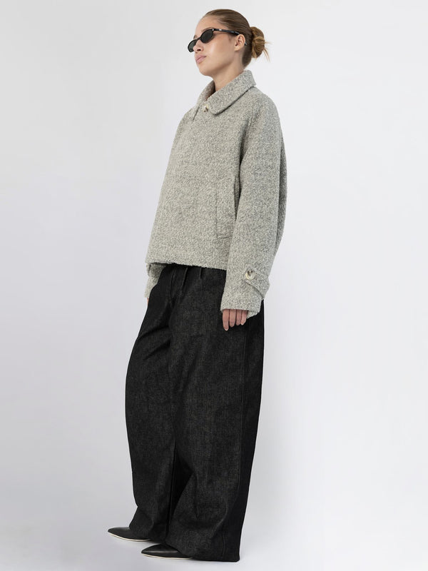 A model showcases a cozy gray sweater paired with oversized black trousers, embodying a relaxed yet stylish look by MEOTINE.