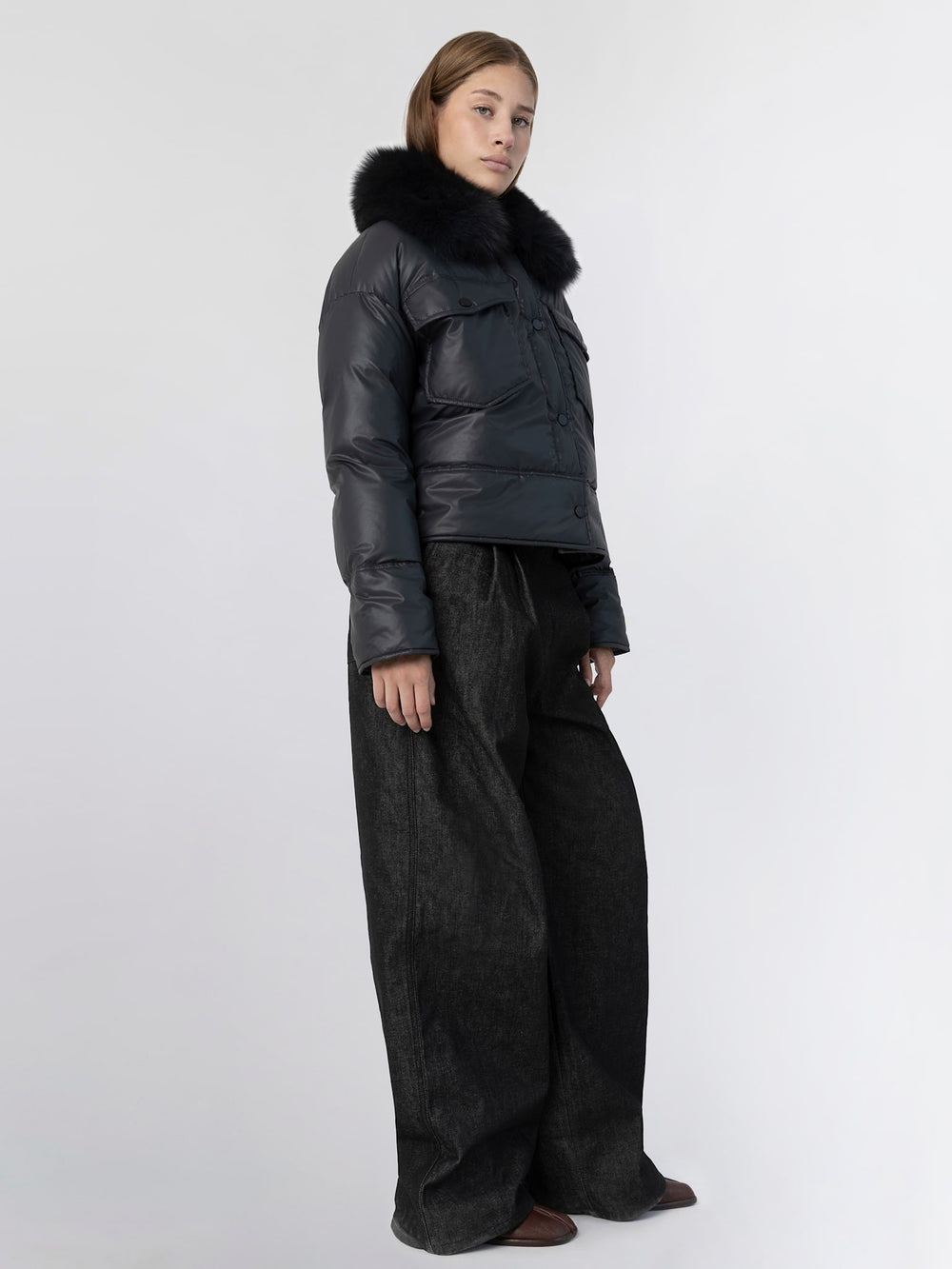 Stylish black puffer jacket with a luxurious fur collar, perfect for winter, by MEOTINE. Model poses confidently.