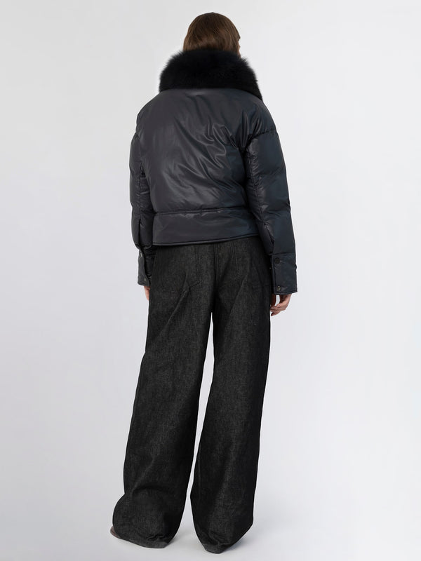 Stylish black puffer jacket with a fur collar, paired with wide-leg dark trousers, showcasing a modern winter look by MEOTINE.