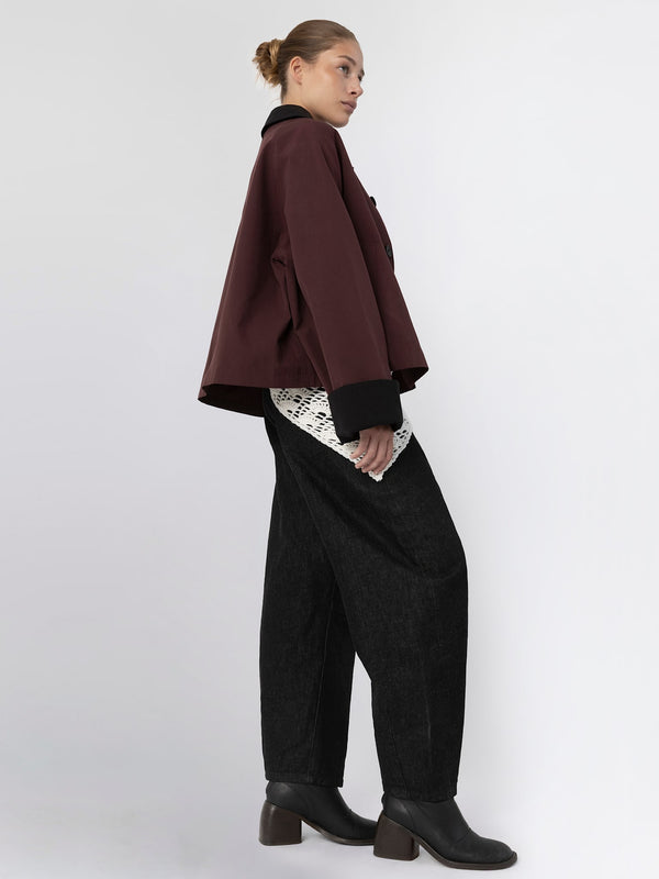 A model showcases a stylish maroon jacket paired with black wide-leg pants, embodying MEOTINE's modern aesthetic.