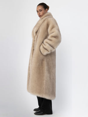 A model showcases a luxurious beige faux fur coat by MEOTINE, featuring a wide collar and side pockets, exuding elegance.