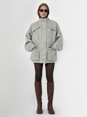 A model wears a cozy gray MEOTINE jacket with a high collar, paired with black leggings and stylish brown knee-high boots.