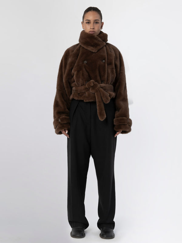 Brown faux fur jacket with a belted waist, paired with loose black trousers, showcasing a stylish and cozy look by MEOTINE.