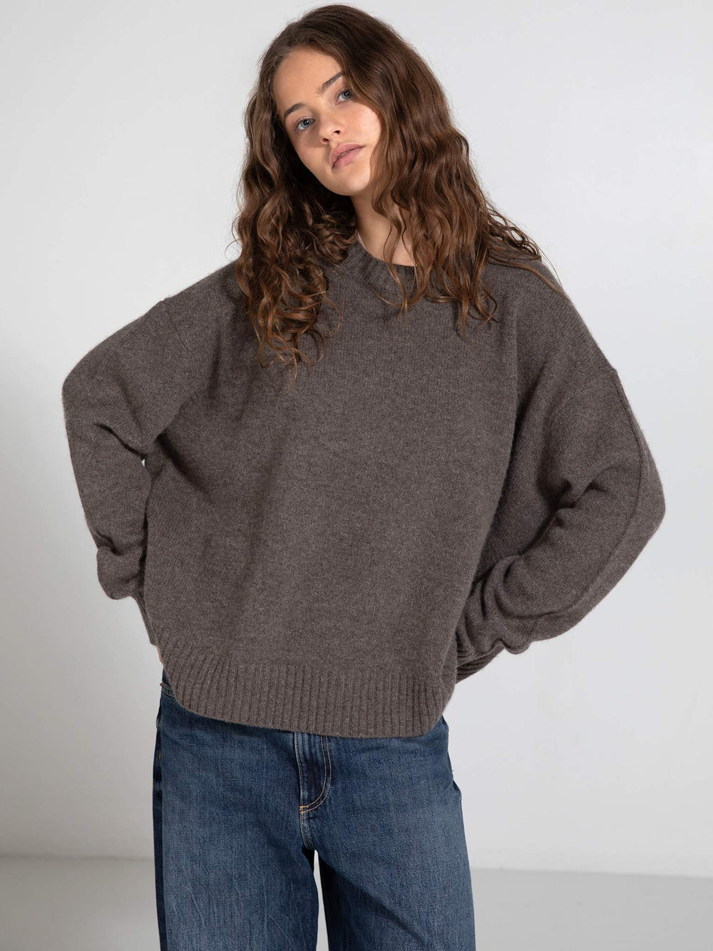 Cozy brown oversized sweater paired with wide-leg jeans, showcasing a relaxed style perfect for casual outings. MEOTINE.