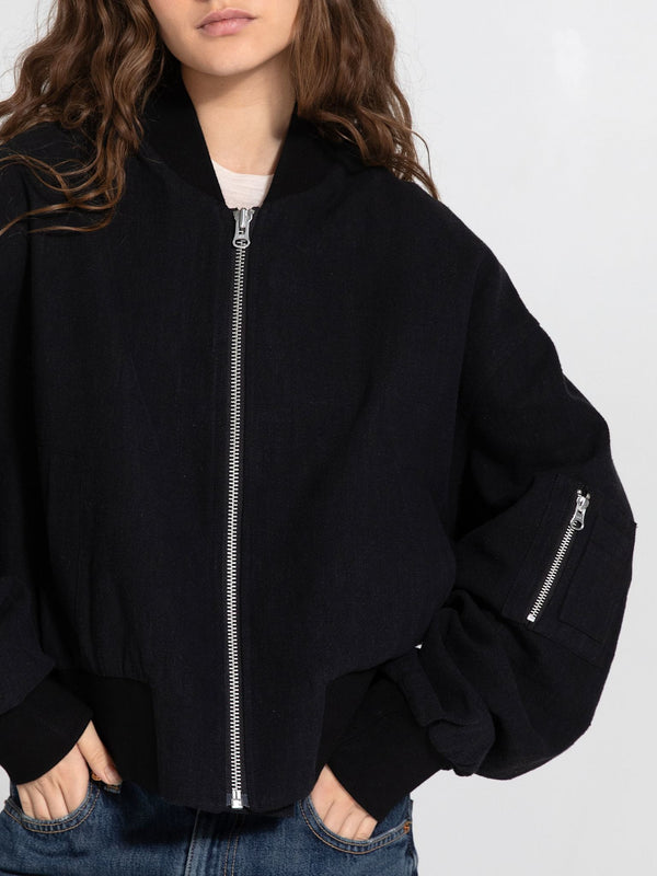 Casual black bomber jacket with a zip front and oversized sleeves, styled by MEOTINE, perfect for a relaxed look.