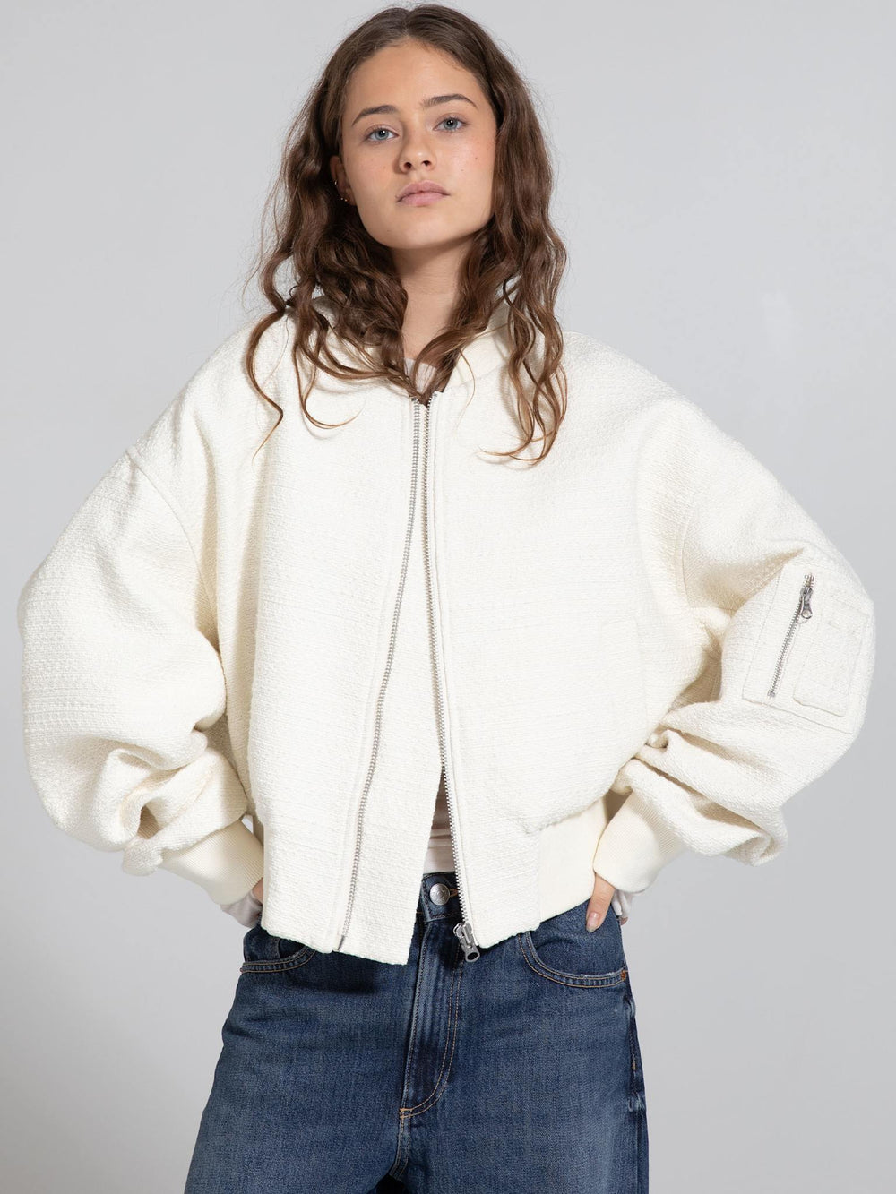 A model showcases a cozy, oversized cream jacket with a textured finish, styled with casual denim, embodying MEOTINE's chic aesthetic.