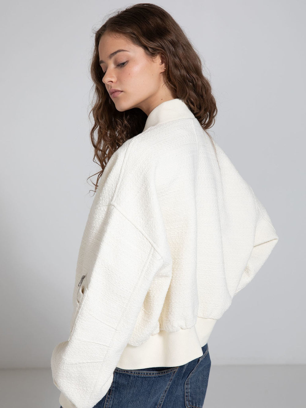 A model showcases a cozy, oversized cream jacket with a textured finish, styled with casual denim, embodying MEOTINE's chic aesthetic.