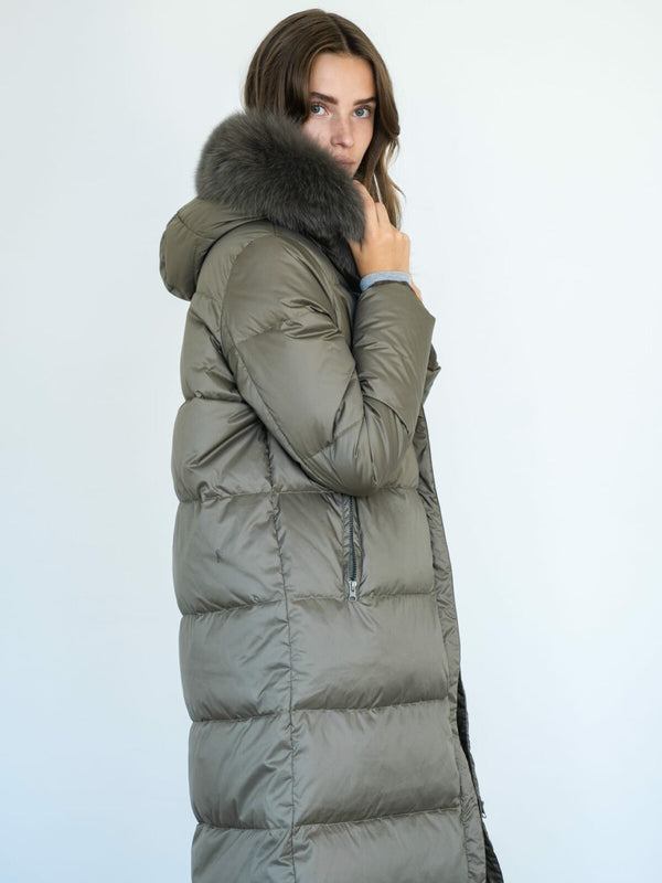 A model poses in a stylish olive green puffer coat with a luxurious fur hood, showcasing MEOTINE's chic winter fashion.