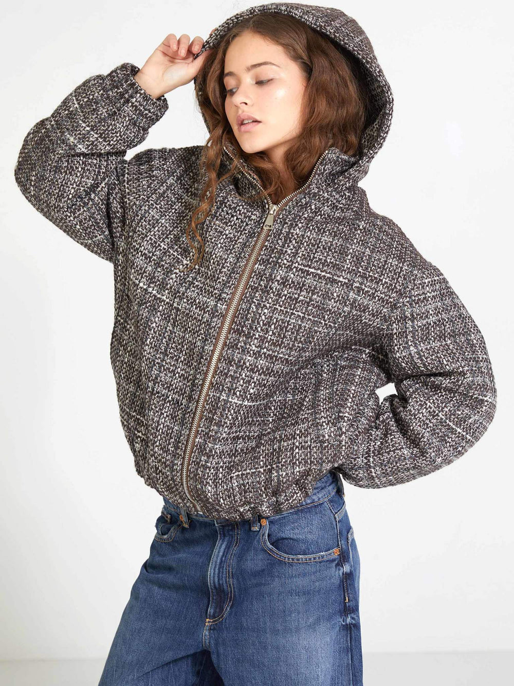 Stylish woman in a cozy, oversized plaid jacket with a hood, paired with denim jeans, showcasing MEOTINE's chic design.