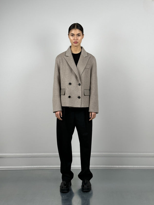 A model wears a stylish beige double-breasted jacket paired with black wide-leg trousers, showcasing MEOTINE's modern aesthetic.