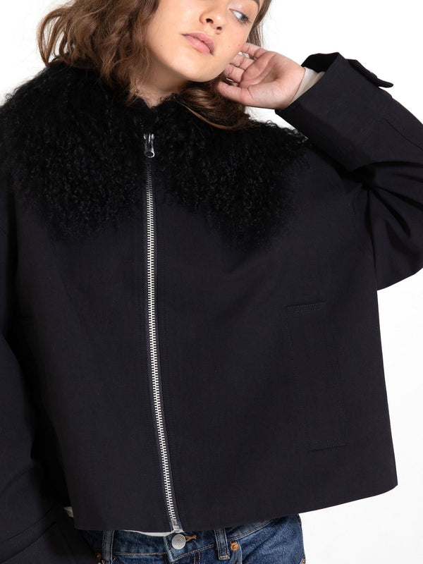 A model showcases a stylish black jacket with a fluffy collar, embodying modern elegance by MEOTINE.
