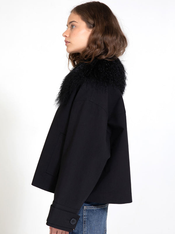 A model showcases a stylish black jacket with a fluffy collar, embodying MEOTINE's chic and modern aesthetic.