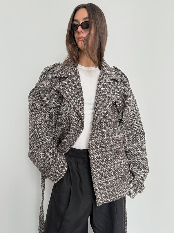 A model showcases a stylish oversized plaid jacket by MEOTINE, paired with a simple white top and black trousers.