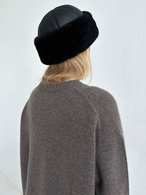 A woman with long blonde hair wears a cozy gray sweater and a stylish black fur hat, showcasing MEOTINE's chic winter fashion.