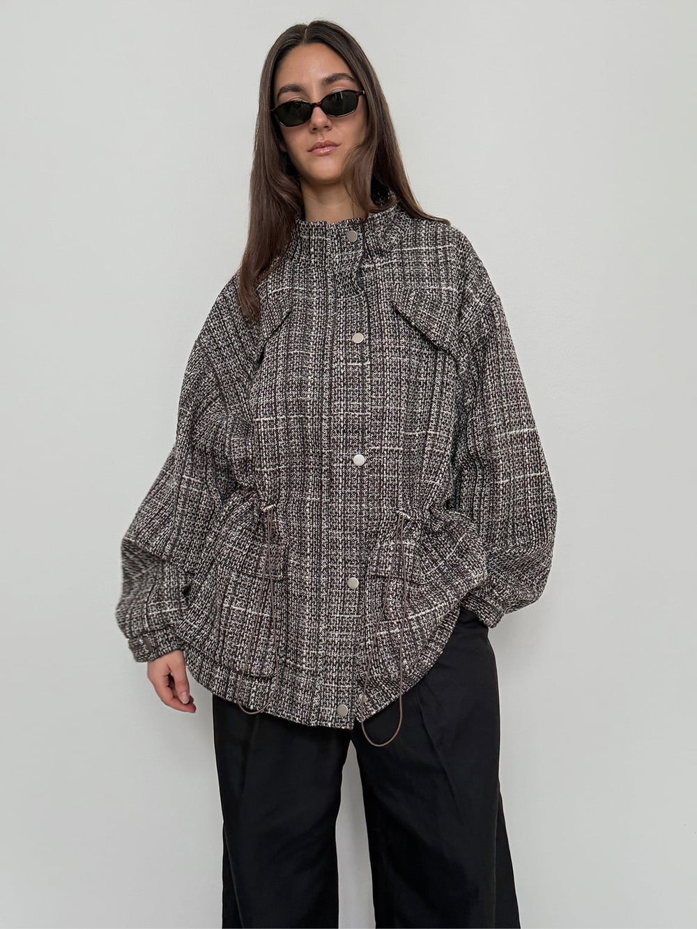 A model showcases a stylish, oversized MEOTINE jacket with a textured pattern, paired with black pants and sunglasses.