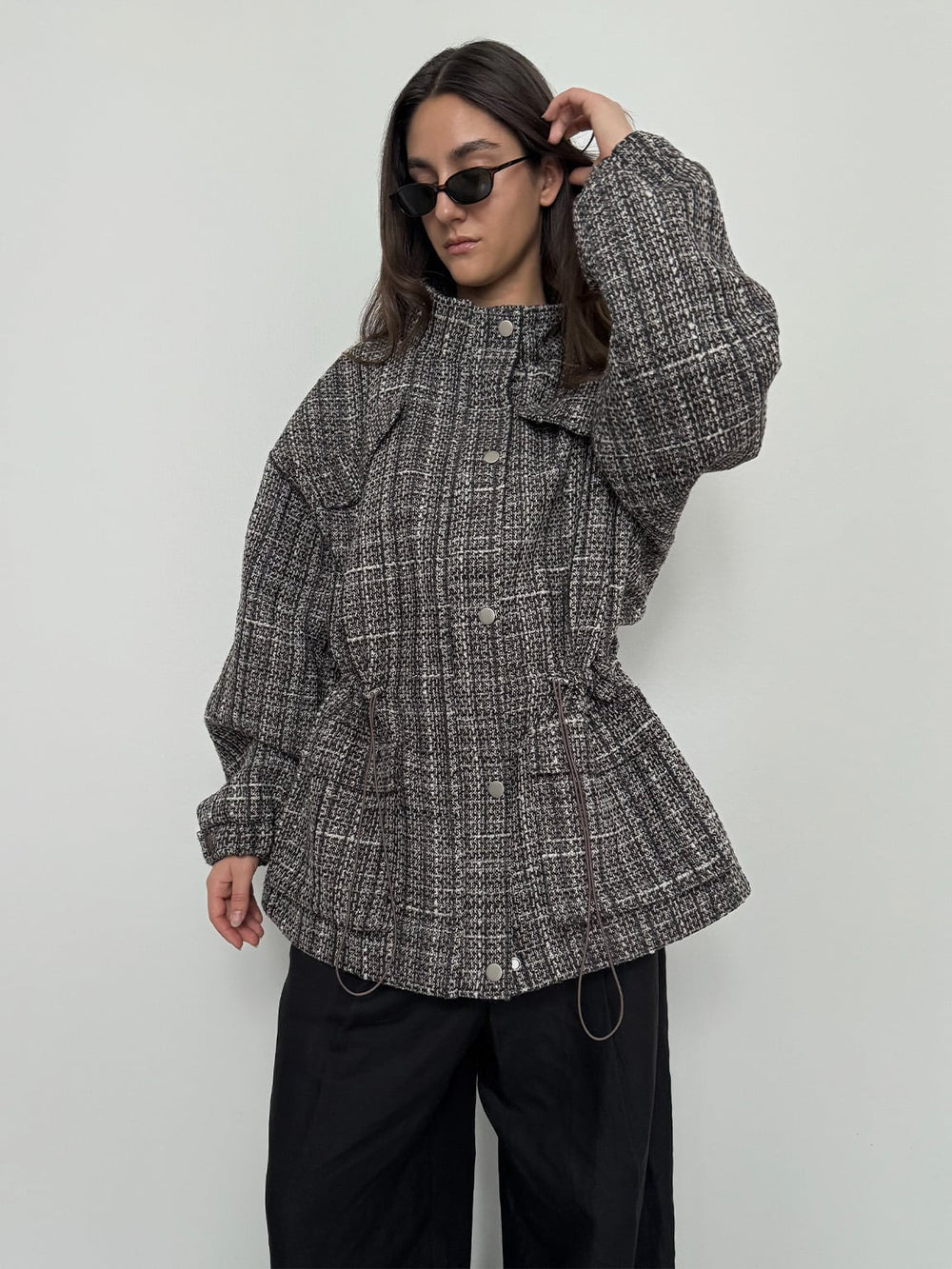 A model showcases a stylish, oversized MEOTINE jacket with a textured pattern, paired with black pants and sunglasses.