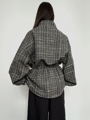 Stylish oversized black and white checkered shirt with a high collar and cinched waist, perfect for a chic look by MEOTINE.