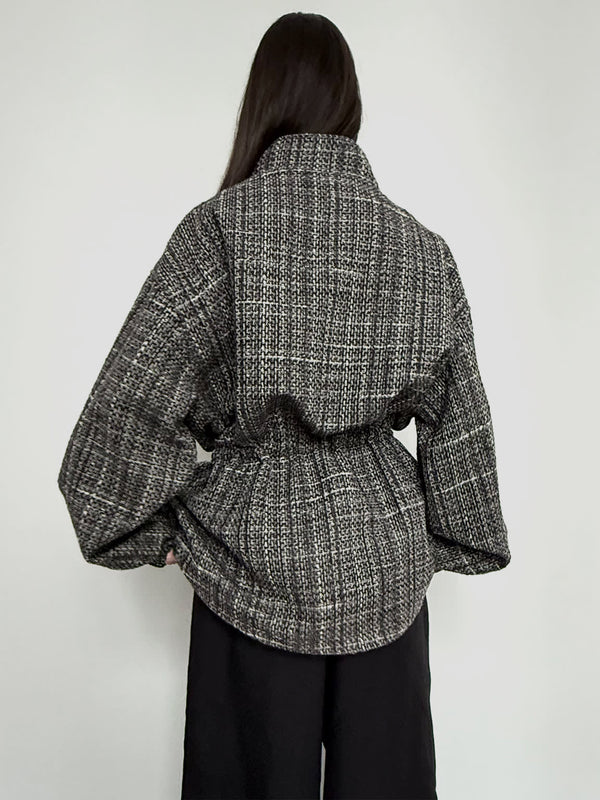 Stylish oversized black and white checkered shirt with a high collar and cinched waist, perfect for a chic look by MEOTINE.