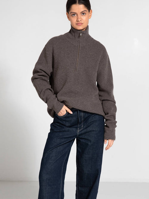 Cozy brown zip-up sweater with ribbed texture, paired with loose-fitting dark jeans, showcasing a relaxed style by MEOTINE.