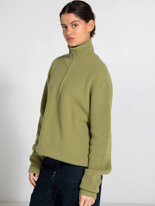 Cozy olive green zip-up sweater with a high collar, featuring ribbed texture and relaxed fit, perfect for casual wear. MEOTINE.