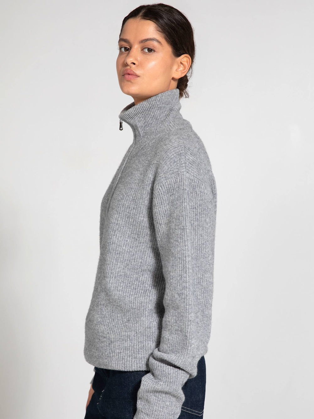 A model wears a gray zip-up sweater and black wide-leg pants, showcasing a stylish, casual look by MEOTINE.