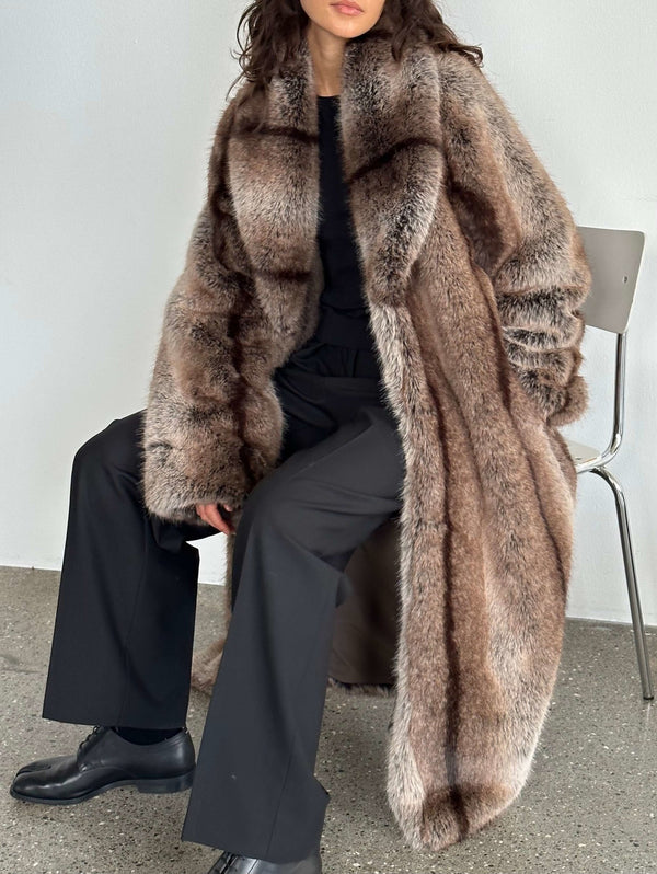 Luxurious faux fur coat by MEOTINE, featuring a plush texture and oversized fit, styled with black pants and a sleek top.