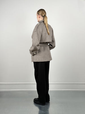 A model showcases a stylish brown cropped jacket with a belted waist, paired with black wide-leg pants, by MEOTINE.