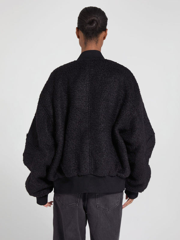 Oversized black bomber jacket with a textured finish, featuring a relaxed fit and ribbed cuffs, by MEOTINE.