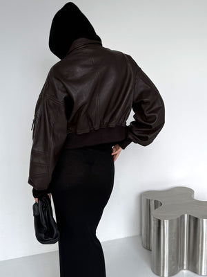 Chic brown leather cropped jacket with a relaxed fit, paired with a sleek black dress, showcasing a modern, stylish look by MEOTINE.