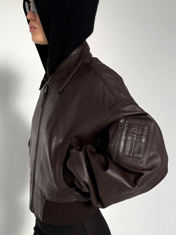 Stylish brown leather bomber jacket with a relaxed fit, featuring a zip pocket and ribbed cuffs, perfect for a trendy look by MEOTINE.
