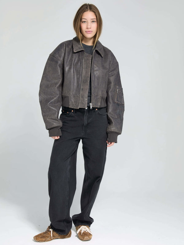 Stylish cropped leather jacket in dark brown, paired with black high-waisted jeans and casual sneakers, showcasing MEOTINE's modern aesthetic.