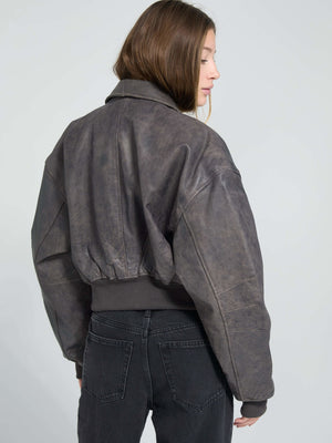 Stylish cropped leather jacket in a dark, textured finish, featuring a relaxed fit and ribbed hem, perfect for a trendy look. MEOTINE.