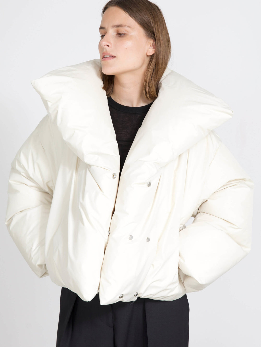 A model wears a stylish oversized white puffer jacket with a dramatic collar, showcasing MEOTINE's modern design.