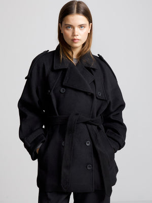 A model wears a stylish black oversized coat with a belt, showcasing a chic and modern look by MEOTINE.