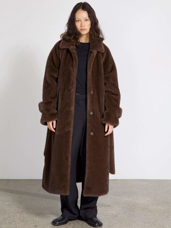 A model wearing a cozy brown faux fur coat over a black outfit, showcasing the stylish design of MEOTINE's outerwear.