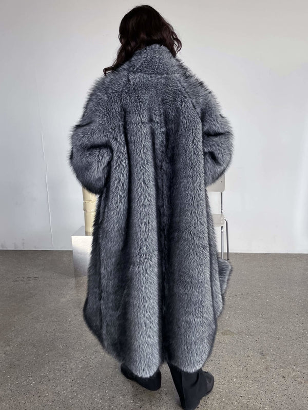 Luxurious gray faux fur coat drapes elegantly on a model, showcasing a cozy and stylish look by MEOTINE.