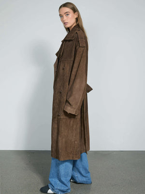 A model showcases a stylish brown suede trench coat by MEOTINE, paired with relaxed blue jeans and black sneakers.