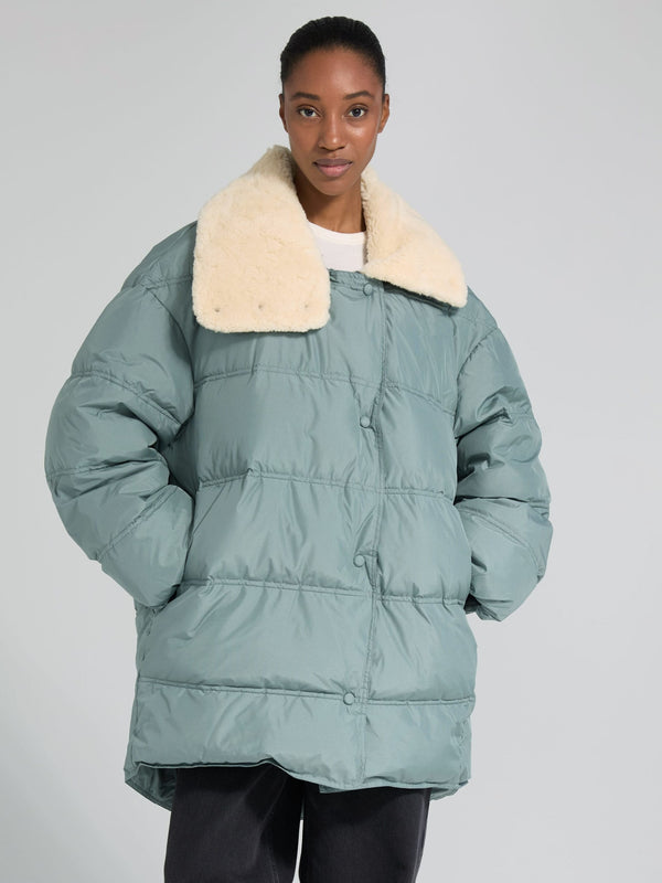 Cozy oversized puffer jacket in soft green with a plush cream collar, perfect for stylish warmth this season by MEOTINE.