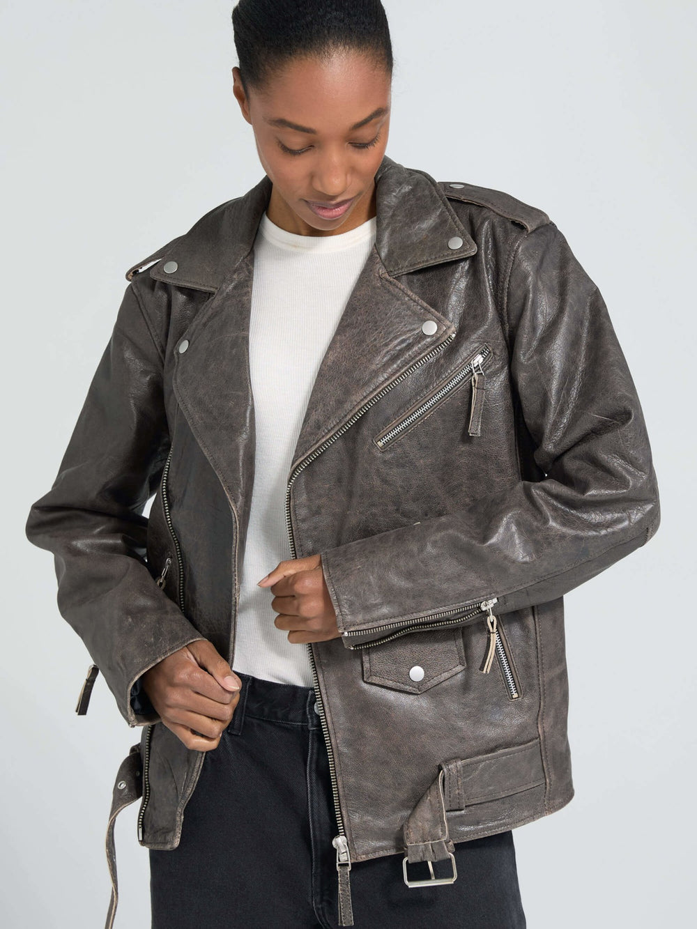 Stylish brown leather jacket with a classic biker design, featuring zippers and a belted waist, by MEOTINE.