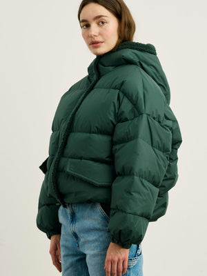 A model wears a stylish green puffer jacket with a cozy collar, paired with light blue jeans, showcasing MEOTINE's trendy design.