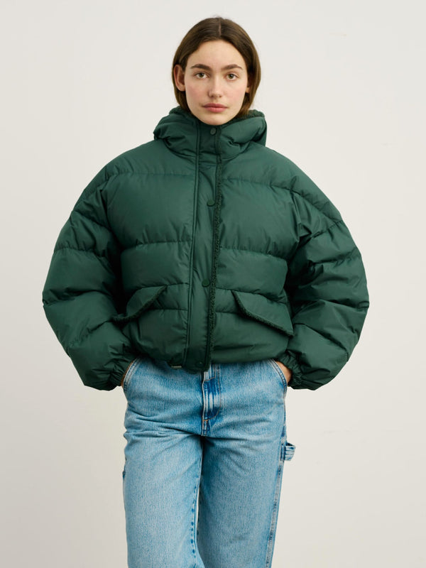 A model wears a cozy green puffer jacket with a hood and front pockets, showcasing MEOTINE's stylish winter outerwear.